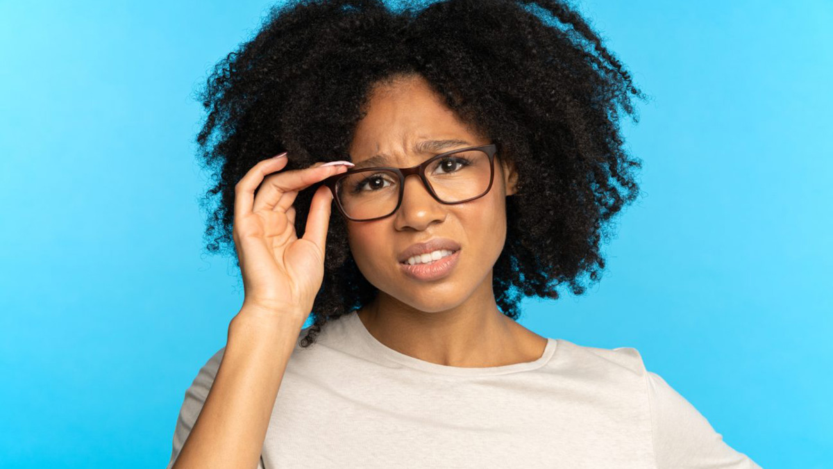 Frau richtet skeptisch blickend den Sitz ihrer Brille