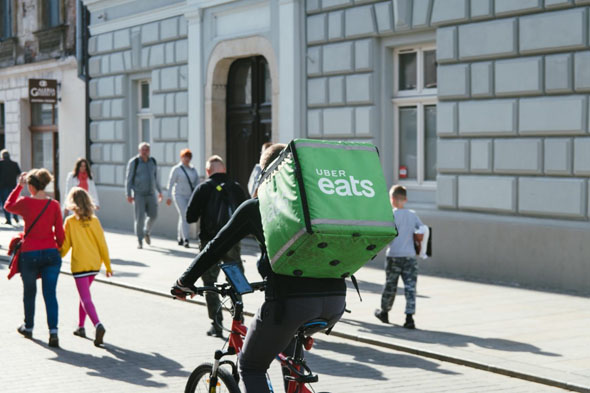 Radfahrer mit Uber-Transportbox