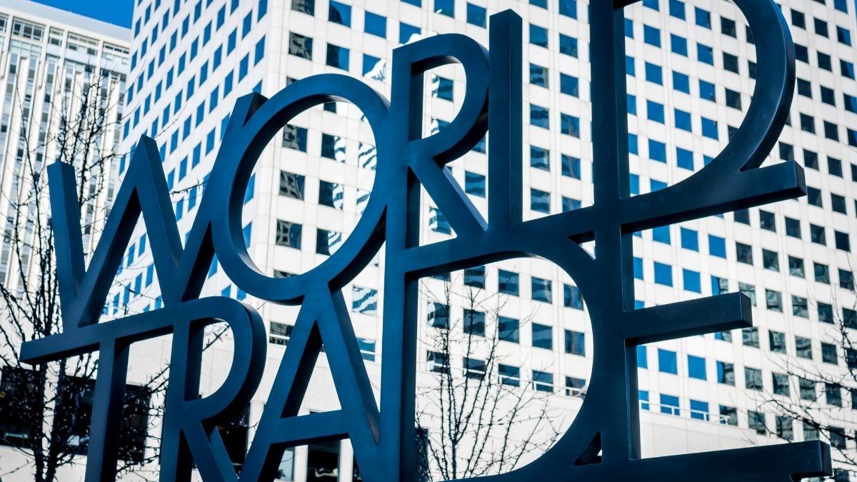 Schriftzug-Skulptur "World Trade" vor Gebäuden