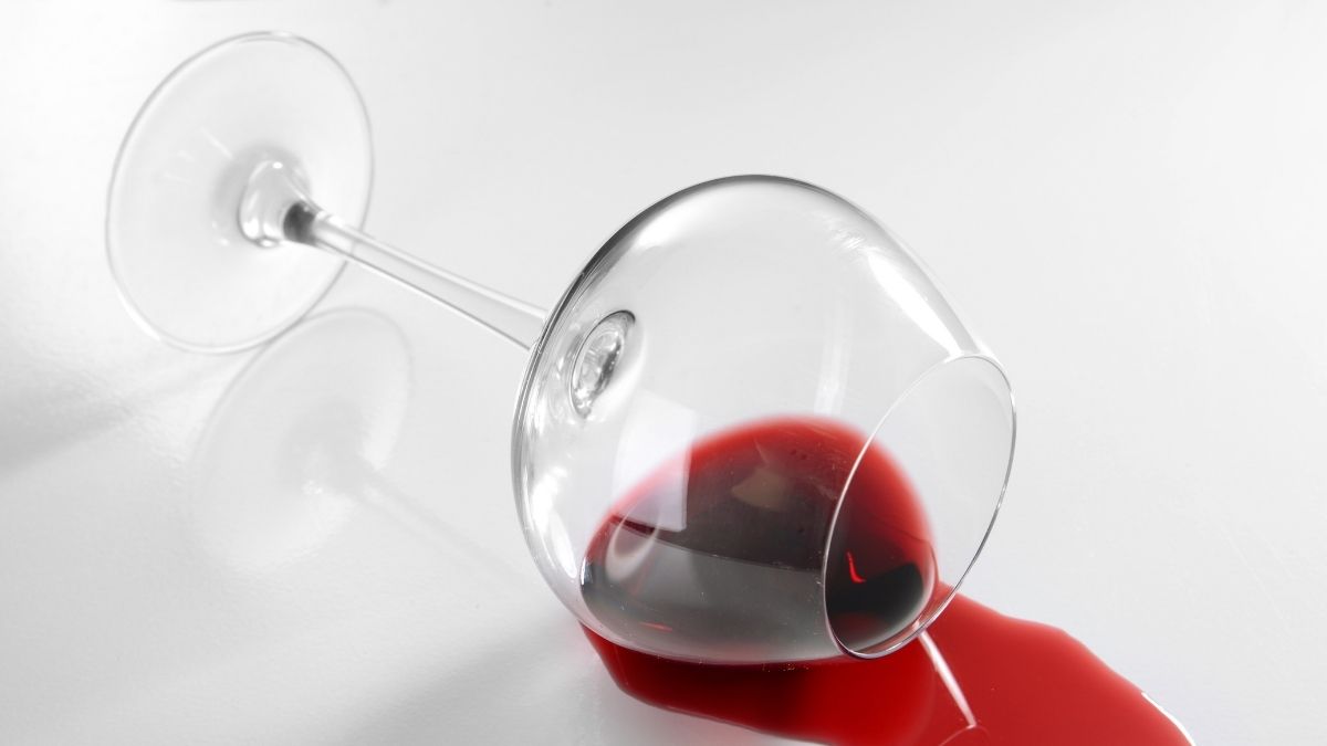 Umgestürzes Glas mit ausgelaufenem Rotwein
