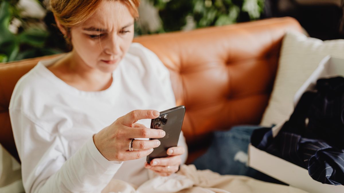 Frau blickt verärgert auf ihr Smartphone