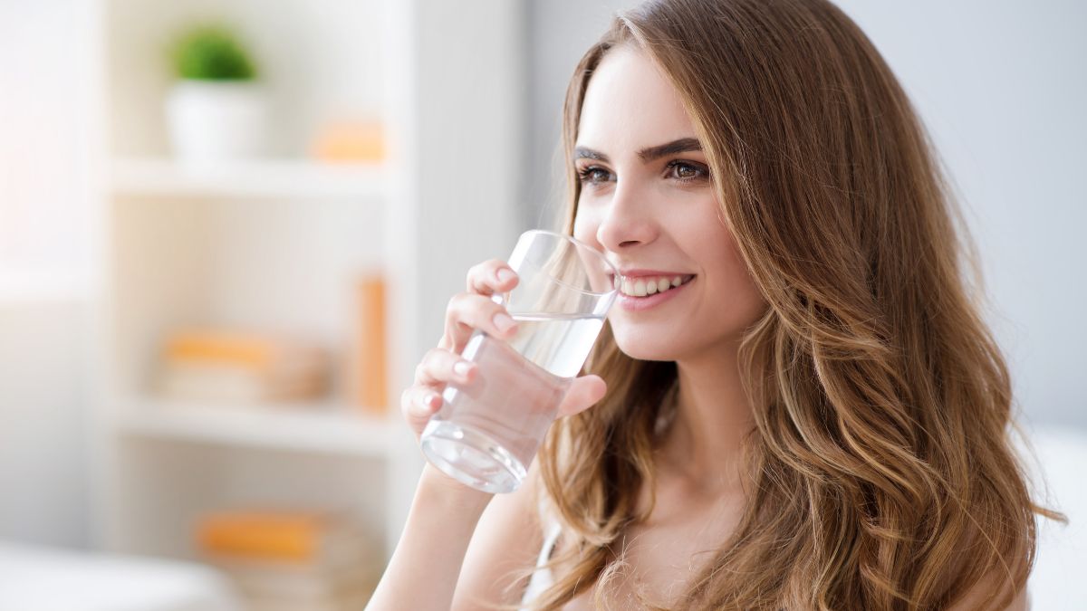 Frau trinkt Wasser aus einem Glas