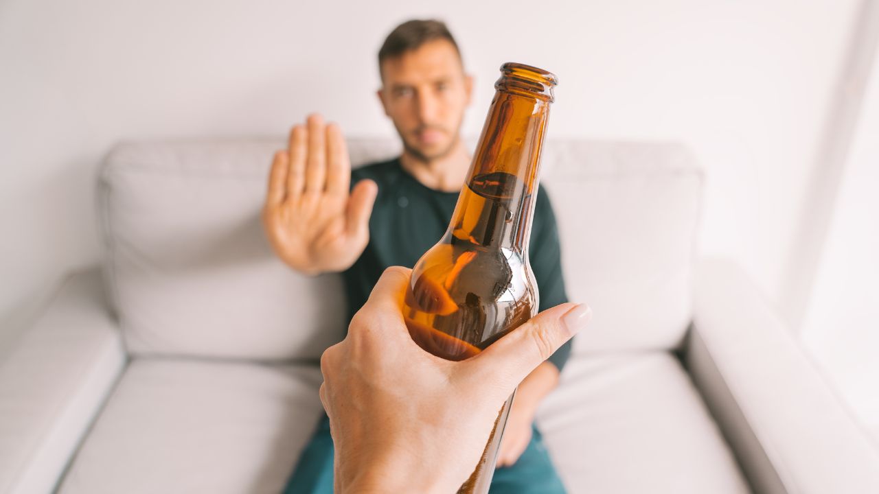 Junger Mann weigert sich, Bier zu trinken.