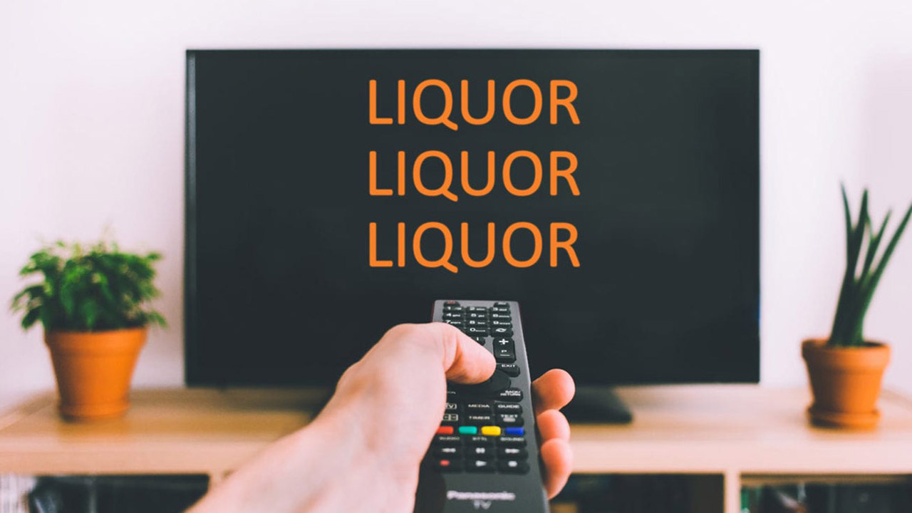 Hand mit Fernbedienung zeigt auf Fernsehbildschirm,auf dem dreimal 'Liquor' steht.