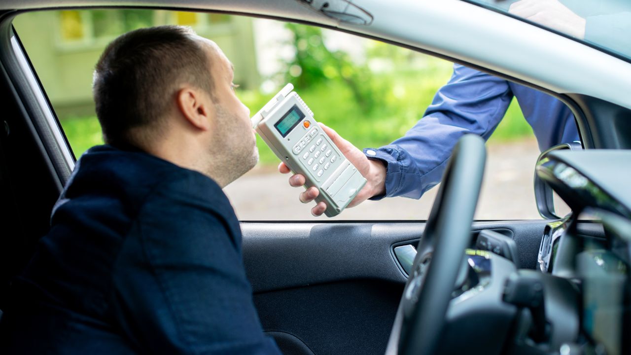 Ein Autofahrer bläst in ein Atemalkoholtestgerät.