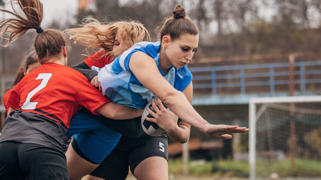 Spielszene von drei Frauen bei einem Rugby-Spiel.