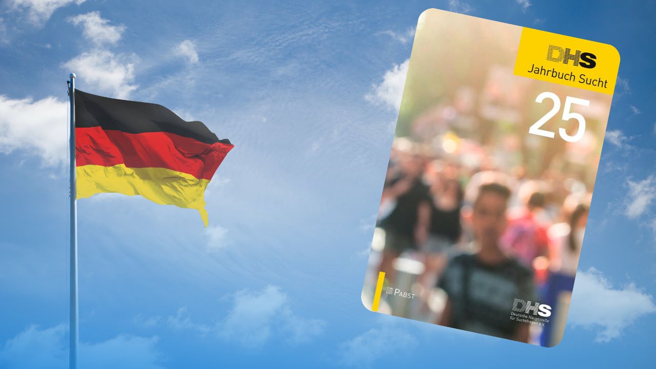 Titelbild des Jahrbuchs Sucht 2025 neben wehender Deutschlandflagge vor blauem Himmel.