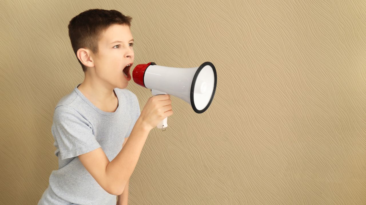 Kleiner Junge ruft mit Megaphon.