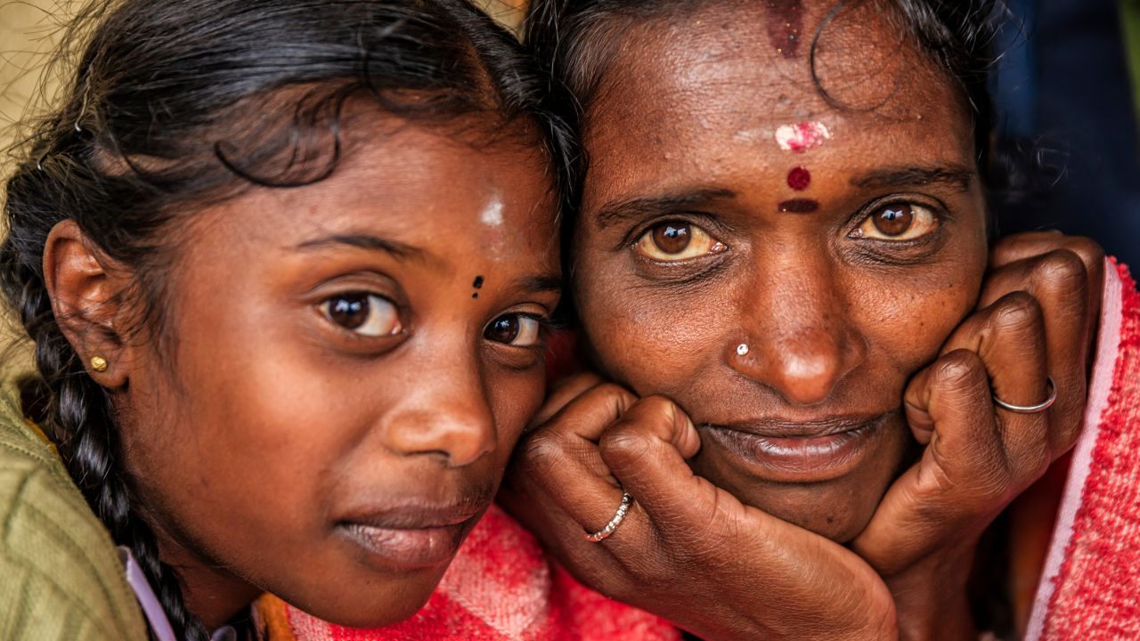 Ein junges Mädchen aus Sri Lanka und ihre Mutter wärmen sich nach der Arbeit gegenseitig.