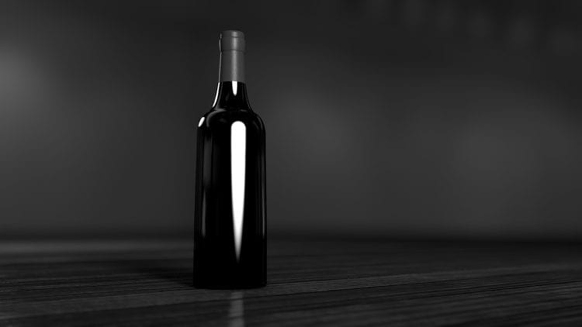 Schwarz-Weiß-Foto einer unetikettierten Flasche auf Tisch stehend