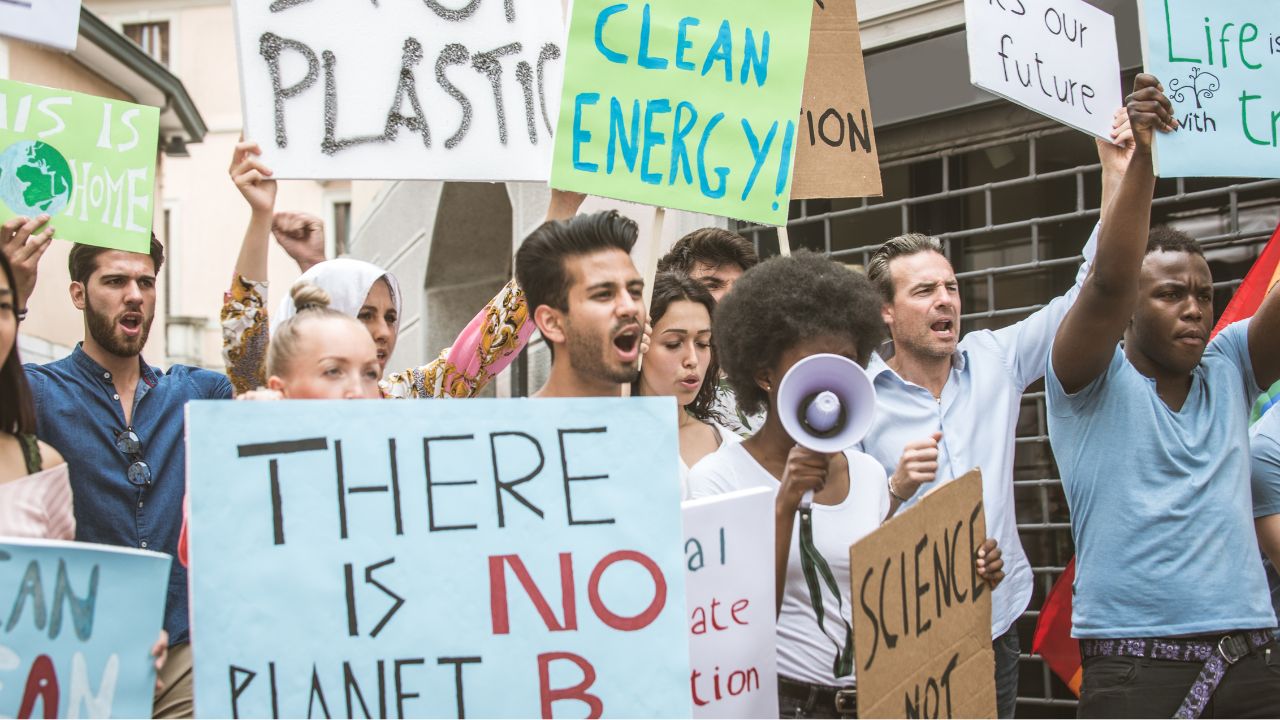 Demonstrant*innen mit Plakaten zu Klimaschutzforderungen.