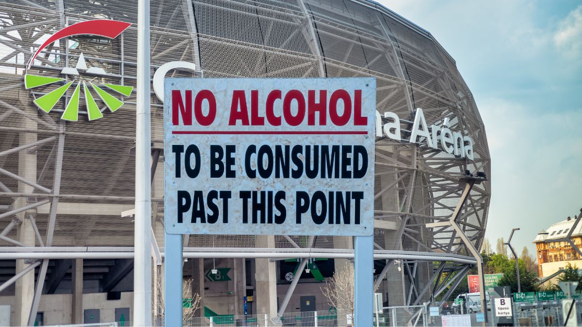 Schild mit Aufschrift 'Kein Alkohol nach diesem Punkt konsumieren' vor Stadion