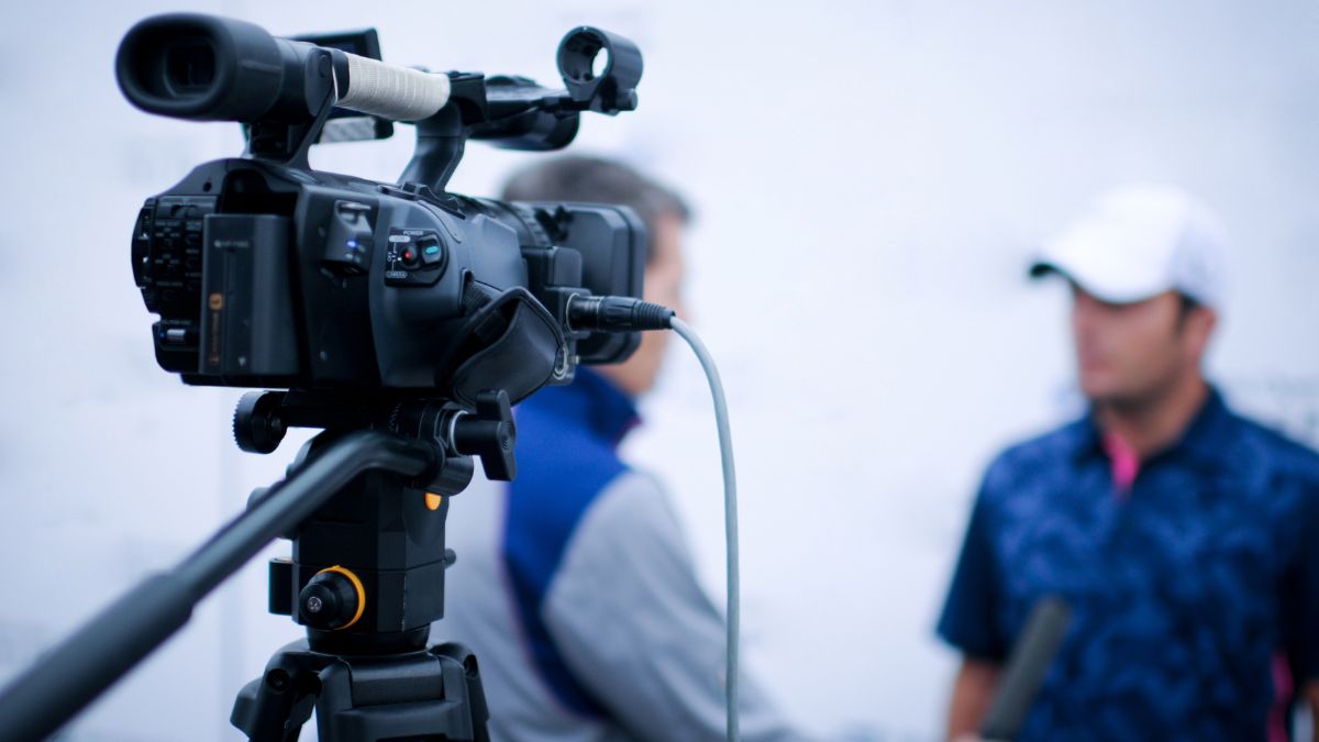 Fernsehkamera vor zwei verschwommenen Männern im Hintergrund